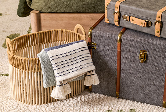 Intricate wicker baskets holding colorful decorative pillows.